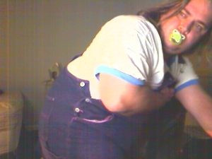 Taking off my jumper to show off my diapers and baby plastic pants.